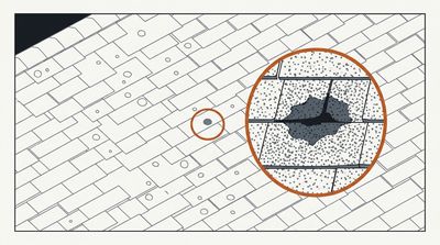 Overhead view of a shingle roof with hail impact marks, one magnified in a detail circle
